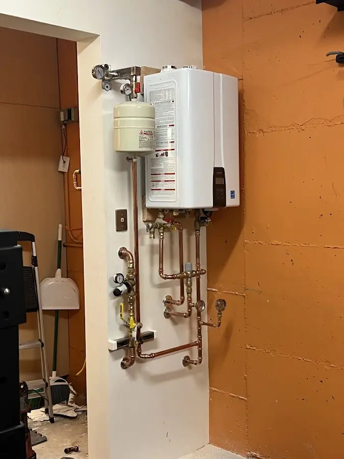Plumbing technician inspecting water heater connections in Lincoln Heights